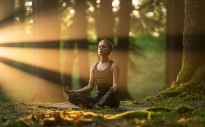 Person praktiziert tiefe Bauchatmung im Wald, um den Parasympathikus aktivieren zu können und Stress abzubauen. Aktivierung Parasympathikus Übungen