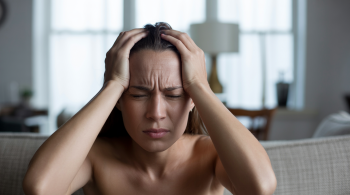 Person mit Anzeichen von Überforderung zeigt was tun bei akutem Stress in einer belastenden Situation