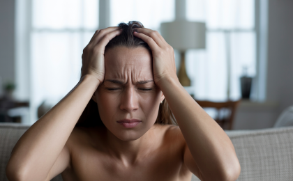 Person mit Anzeichen von Überforderung zeigt was tun bei akutem Stress in einer belastenden Situation