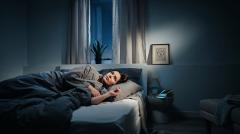 Stress und Schlafstörungen. Person mit Schlafproblemen liegt nachts wach im Bett, während Stress und innere Unruhe den Schlaf beeinträchtigen.